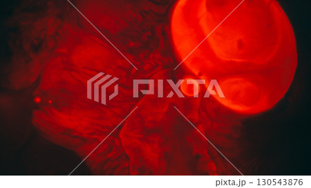 Liquid spot. Stains oil background. Defocused red neon color water splatter paint round flow fluid on abstract dark black texture. 130543876