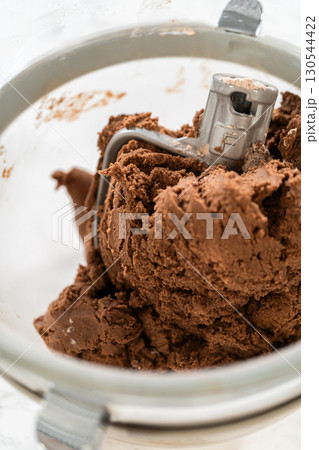 Thick, chocolatey dough formed in the stand mixer for Chocolate Ginger Sugar Cookie Dough, capturing the final texture before shap 130544422
