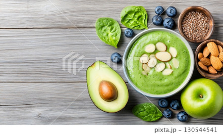 Fresh Healthy Green Smoothie with Spinach, Avocado, Blueberries, and Almonds on Wooden Table 130544541