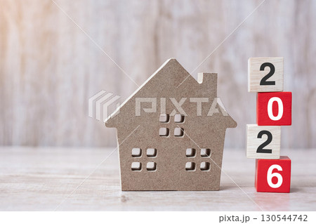 2026 Happy New Year with house model on table wooden background. Banking, real estate, investment, financial, savings and New Year Resolution concepts 130544742