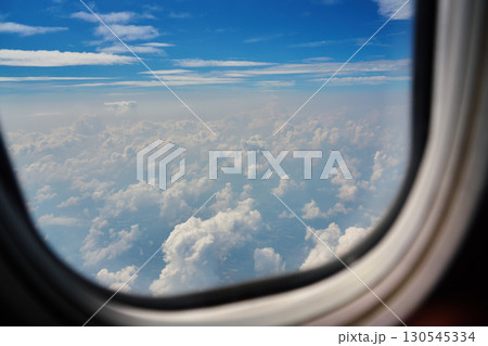 View of clouds through airplane window during flight 130545334