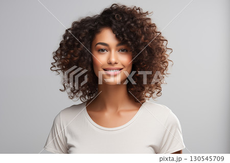 Portrait of a beautiful young woman smiling and looking at camera isolated on a white background Portrait of a beautiful young woman smiling and looking at camera isolated on a white background 130545709