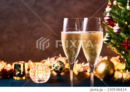 クリスマスツリーとイルミネーション前のシャンパングラスで乾杯 クリスマスツリーとイルミネーション前のシャンパングラスで乾杯 130546814