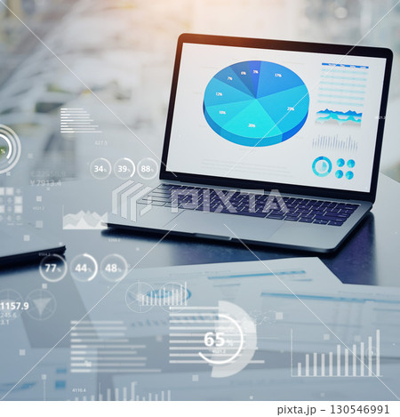 オフィスに置かれたノートPCと統計データ　バナー・広告向け正方形ビジュアル 130546991