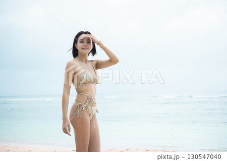 海を眺める水着の若い女性 130547040