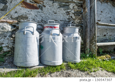Milk containers produced by peasants in the mountains 130547307
