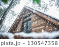 Wooden house in forest during snowfall with winter landscape scenery 130547358
