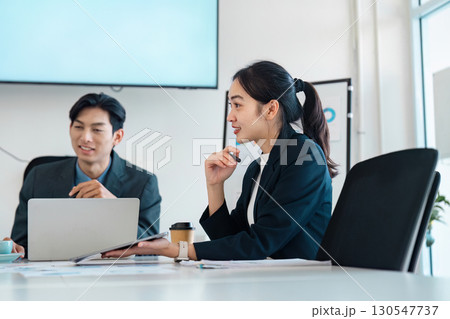 Collaborative business discussion between professionals in a meeting setting. Collaborative business discussion between professionals in a meeting setting. 130547737