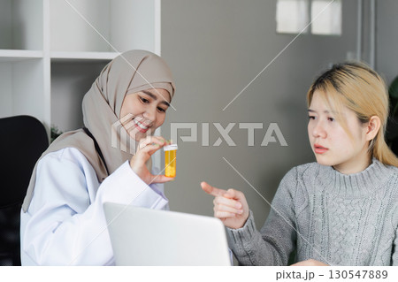 Knowledgeable Muslim female doctor discussing medication with a patient in a modern healthcare office, highlighting patient education and diversity. Knowledgeable Muslim female doctor discussing medication with a patient in a modern healthcare office, highlighting patient education and diversity. 130547889