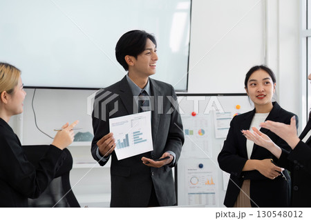 Businessman presenting financial report to team during a meeting. 130548012
