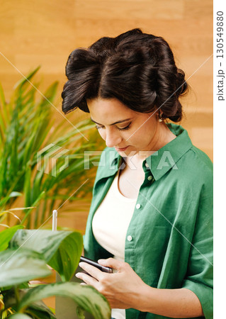 Portrait of woman with hair rollers during slow morning. 130549880