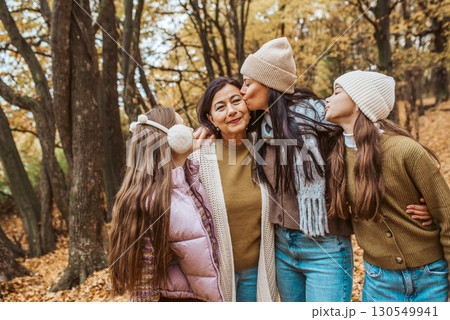 Mature daughter, grandmother and granddaugters on walk in autumn forest. Mature daughter, grandmother and granddaugters on walk in autumn forest. 130549941