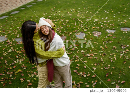 Portrait of beautiful mother with young daughter in the middle of autumn garden. 130549993