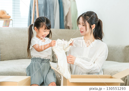 家で引越しの荷造り,不用品整理,レンタル,サブスク,ネットショッピング,洋服を買う親子 130551293