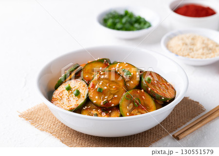 Korean cucumber salad (Oi muchim) in bowl on white background, Korean side dish Korean cucumber salad (Oi muchim) in bowl on white background, Korean side dish 130551579