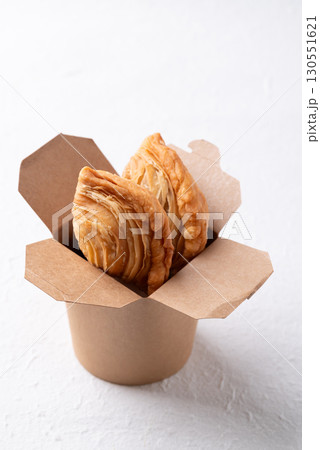 Thai Curry puff stuffed with chicken or sweet potatoes in paper food box on white background 130551621