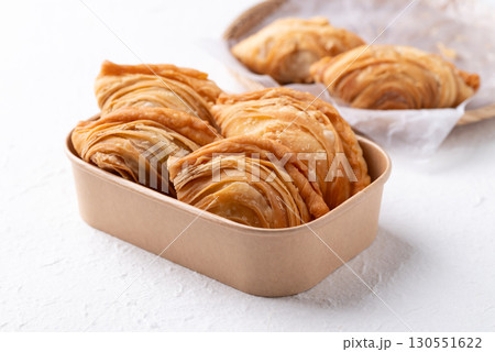 Thai Curry puff stuffed with chicken or sweet potatoes in paper food box on white background 130551622