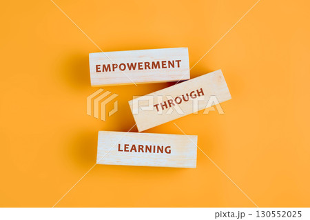 The message connect through learning. EMPOWERMENT THROUGH LEARNING assembled from blocks on orange background, top view The message connect through learning. EMPOWERMENT THROUGH LEARNING assembled from blocks on orange background, top view 130552025