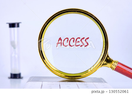 ACCESS text was revealed through a magnifying glass on a light background that was on the calculator. Business and accessible concept. Copy space 130552061