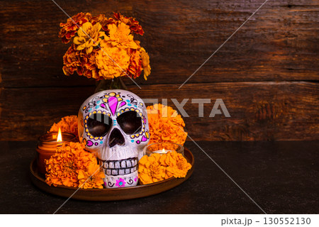 Painted skull with marigold flowers and candles. Dia De Los Muertos altar. 130552130