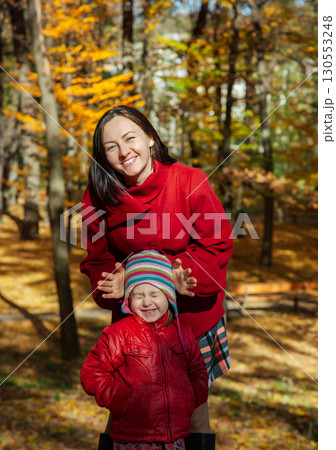 Mother and daughter enjoying sunny autumn day in park. Family togetherness and fall leisure concept 130553248
