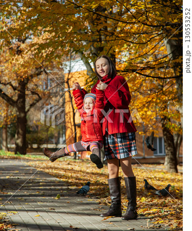 Mother and daughter enjoying sunny autumn day in park. Family togetherness and fall leisure concept 130553252