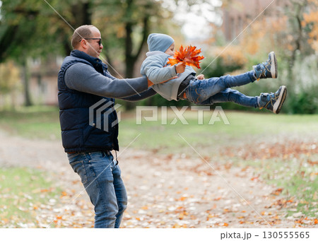 Father and child playing together in nature. Symbol of trust, fun, family connection Father and child playing together in nature. Symbol of trust, fun, family connection 130555565