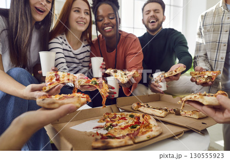 Happy diverse friends having party gathering at home eating pizza talking and laughing together Happy diverse friends having party gathering at home eating pizza talking and laughing together 130555923