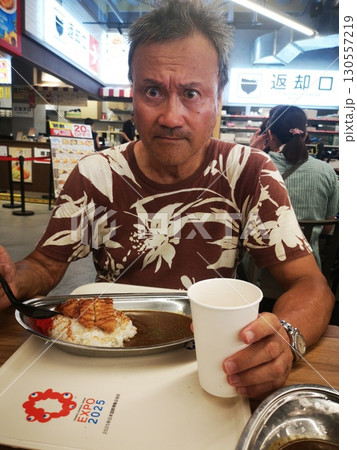 大阪万博でビールを飲みながらカツカレーを食べる男 130557219