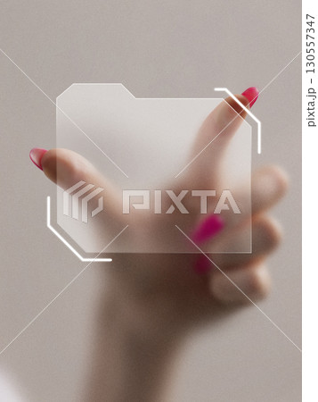 Graphic composition. Hand with pink nails holding transparent digital folder icon in futuristic interface 130557347