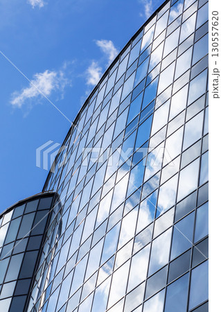 A building with blue sky and clouds reflected in its windows 130557620