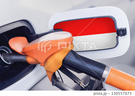 The flag of Indonesia on the lid of the gas tank of a car at a gas station in close-up. High or low gasoline prices at Indonesian gas stations. In Indonesia, gasoline prices are rising due to a 130557873