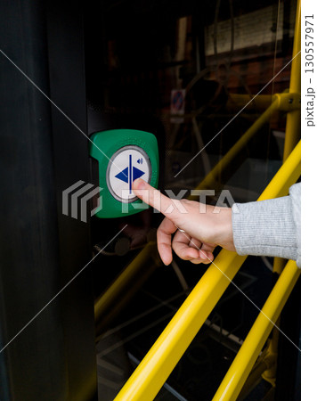 woman presses the button to open doors 130557971