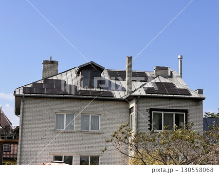 Brick House With Solar Panels on Sunny Day 130558068