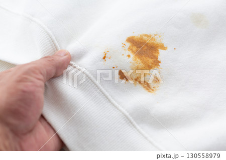 食べこぼしのシミ汚れがついた白いトレーナー 130558979