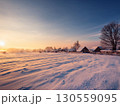 雪原に朝日が差し込む冬の田舎風景と雪化粧の家々｜雪景色、冬、田舎、雪原、日の出、家、自然、静寂 130559095