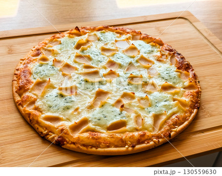 Whole baked pizza with cheese and toppings on wooden board. Food, leisure and culinary lifestyle in homemade dining culture. 130559630