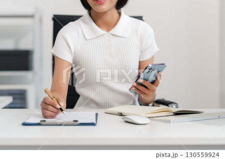 Businesswoman analyzing financial graphs, calculating company expenses, and planning investments, corporate, accounting, and economic strategy. 130559924