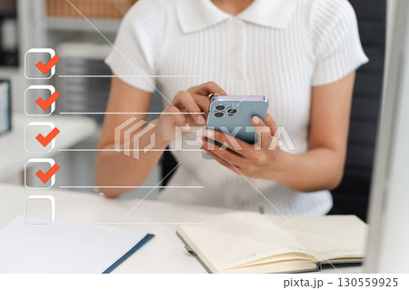 Business performance checklist concept, woman using tablet and laptop doing online checklist survey, filling out digital form checklist. 130559925