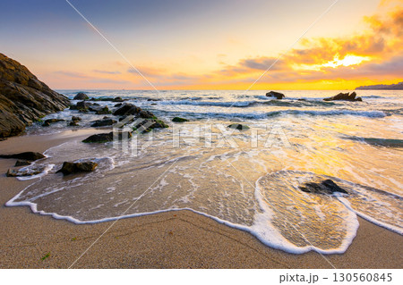 sunrise on the beach. beautiful summer landscape for vacation at the sea. rocks on the sand. calm waves on the water. sun behind clouds on the sky. wide panoramic view of bamboo beach in sozopol 130560845