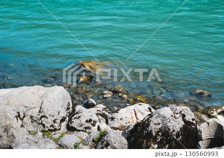 Rocky river bank with blue water on a summer day Rocky river bank with blue water on a summer day 130560993