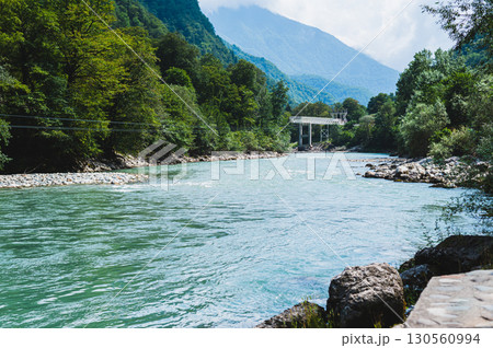 Bungee jumping and metal bridge on a mountain blue rocky river on a summer day Bungee jumping and metal bridge on a mountain blue rocky river on a summer day 130560994