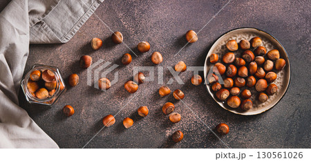 Nutritious hazelnuts on a plate and in a jar on the table top view web banner Nutritious hazelnuts on a plate and in a jar on the table top view web banner 130561026