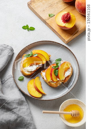 Toasted bruschetta with peach, nectarine, cream cheese or ricotta and honey on a plate Toasted bruschetta with peach, nectarine, cream cheese or ricotta and honey on a plate 130561108