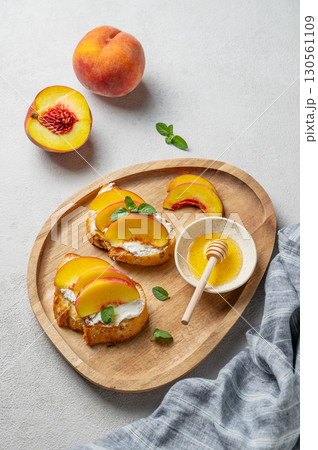 Toasted bruschetta with peach, nectarine, cream cheese or ricotta and honey on a wooden plate Toasted bruschetta with peach, nectarine, cream cheese or ricotta and honey on a wooden plate 130561109