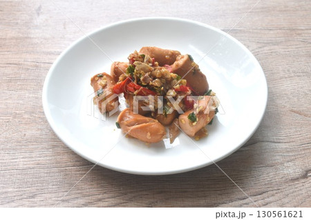 deep fried salty pork sausage with chop garlic and chili pepper arranging on plate deep fried salty pork sausage with chop garlic and chili pepper arranging on plate 130561621
