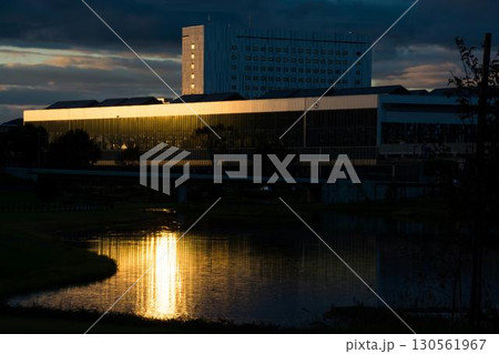 夕陽を反射する建物と水面 130561967