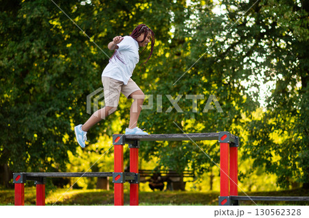 Girl playing at the playground and looking happy and energized Girl playing at the playground and looking happy and energized 130562328