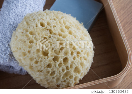 Dermo Aqua soft bath sponge on a wooden background 130563485