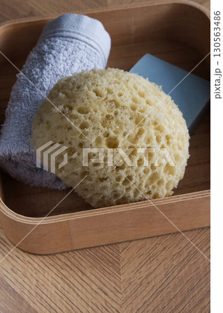 Dermo Aqua soft bath sponge on a wooden background 130563486